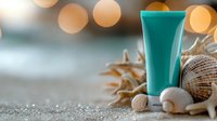 Turquoise cosmetic tube with seashells and starfish on sandy beach setting with soft bokeh lights, spa wellness concept for skincare products.