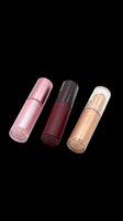 Three cosmetic lip gloss tubes in pink, burgundy, and gold tones, isolated on transparent background. Great for beauty clipart, stickers, t-shirt design, and print on demand.