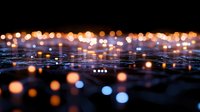 Defocused urban lights creating magical bokeh effect at night with warm orange and cool blue glowing circles against dark background. Atmospheric cityscape.