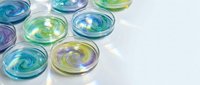 Colorful glass bowls with swirled patterns in blue, green, and purple tones arranged on white surface for modern home decor and kitchen design projects.