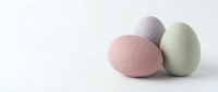 Pastel colored Easter eggs in soft pink, lavender and sage green with delicate floral patterns arranged on clean white background for spring holiday designs.