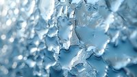 Macro photography of frost ice crystals forming intricate natural patterns in light blue tones. Abstract winter background with detailed crystalline structure.