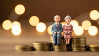 Senior couple figurines sitting on golden coins with warm bokeh lights representing retirement savings and financial security planning.