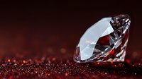 Brilliant cut diamond on dark red glittering surface with dramatic lighting and shallow depth of field, luxury jewelry concept for engagement and wedding designs.