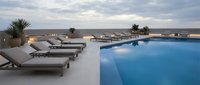 Luxury resort pool terrace with lounge chairs at sunset, modern minimalist design for vacation and hospitality concepts.