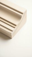Natural wood molding profile with grooved details on neutral background for construction and interior design projects.