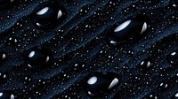 Shiny black water drops on dark blue textured surface with scattered tiny droplets creating dramatic contrast and reflective highlights. For backgrounds and nature concepts.