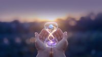 Hands holding glowing hourglass with purple light against blurred sunset background, symbolizing time management, productivity, and business concepts for corporate design.