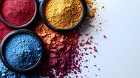 Vibrant makeup pigments in red, yellow, and blue shades with scattered powder texture on light background, cosmetic industry concept for beauty products.