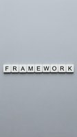 Wooden letter tiles spelling FRAMEWORK on gray background for business strategy and development concepts.