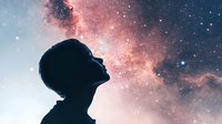Silhouette of person gazing upward at pink nebula and starry night sky, representing wonder, dreams, inspiration and connection with cosmos. Spiritual concept.