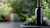 Dark wine bottle on black stone board with fresh green herbs and olives, moody atmospheric composition for wine and food marketing on blurred background.