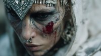 Fantasy warrior woman with intricate face paint and metallic armor in mystical portrait for gaming and medieval themed projects.