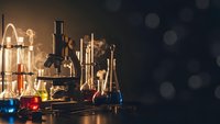 Vintage laboratory equipment with colorful chemical solutions in glass beakers and flasks on dark background with bokeh lights for science education.