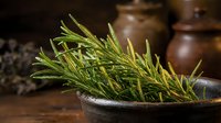 Fresh rosemary sprigs with water droplets in rustic bowl, aromatic herb for cooking, culinary ingredient, natural seasoning.
