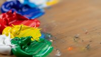 Colorful acrylic paint blobs on wooden palette with brush strokes. Art supplies for creative projects, painting workshops, and artistic expression.