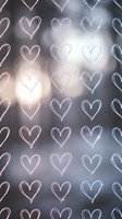 Neon heart shapes pattern with soft bokeh lights creating romantic atmosphere for Valentine's Day designs, wedding invitations, and love-themed projects.