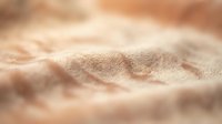 Close-up of fine sand texture with warm, natural lighting creating subtle shadows and depth, suitable for backgrounds, design elements, and nature-themed projects.