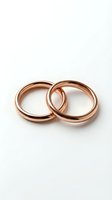 Two interlocked rose gold wedding rings on white background symbolizing marriage commitment and eternal love for wedding planning and jewelry design.