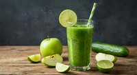Fresh green smoothie with lime, apple and cucumber on rustic wooden table. Healthy detox drink for weight loss and wellness lifestyle.