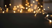 Warm golden string lights creating cozy bokeh atmosphere on dark surface for holiday decorating and festive home ambiance.