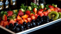 Fresh fruit platter with vibrant strawberries, watermelon cubes, blueberries and kiwi slices arranged on white rectangular serving plate, perfect for healthy eating.