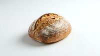 Freshly baked artisan sourdough bread loaf with golden crust and flour dusting isolated on white background for bakery and food design projects.