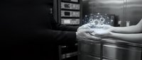 Hands holding glowing digital gear icon above server equipment in data center, representing cloud computing, network management, and IT infrastructure technology solutions.