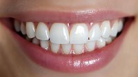 Close up view of healthy white teeth and pink lips showing genuine smile with natural dental alignment and oral hygiene for dental care concept.