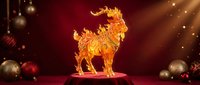 Golden ornate rooster figurine with intricate decorative patterns displayed on red velvet surface surrounded by festive ornaments and warm lighting.