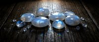 Blue moonstone gemstones collection on rustic wooden surface for jewelry making and crystal healing practices.
