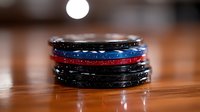 Stack of poker chips in black, blue and red colors on wooden table with soft focus background and dramatic lighting creates atmosphere for casino gaming.