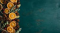 Dried orange slices, star anise, and eucalyptus leaves arranged on teal textured surface for holiday, wellness, and seasonal design projects.