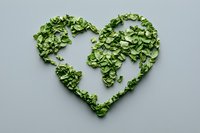Heart shaped world map made from fresh green leaves on gray background, representing eco-friendly, sustainable living and environmental conservation concept.