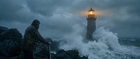 Dramatic lighthouse beam cutting through stormy waves as lone figure watches from rocky shore during tempestuous weather conditions at dusk.