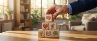 Businessman hand stacking wooden blocks with business icons representing growth strategy and development in modern office environment.