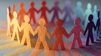 Colorful paper cutout figures holding hands in a row, symbolizing diversity, unity, and community connection on textured surface with cast shadows.