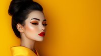 Asian woman with bright red lips and dramatic eye makeup wearing yellow garment against vibrant yellow background. Professional beauty portrait with modern makeup trends.