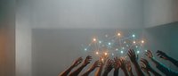 Diverse hands reaching upward toward glowing connected network lights, symbolizing teamwork, collaboration, and digital transformation in modern business environments.