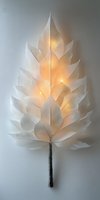 Illuminated white paper leaf sculpture with warm golden light glowing through translucent layers creating artistic shadow patterns on neutral background.