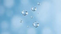 Transparent water drops of various sizes floating on a soft blue bokeh background, conveying freshness, purity, and hydration concepts.