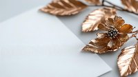 Metallic copper rose gold leaves and flower on light gray background with copy space. Elegant floral arrangement for luxury design projects.