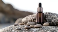 Brown glass dropper bottle for essential oil or serum on natural stone arrangement against blurred background, wellness and spa concept for skincare products.