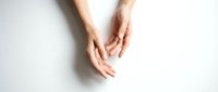 Gentle female hands positioned in protective cupping gesture on clean white background, symbolizing care, protection and nurturing support concepts.
