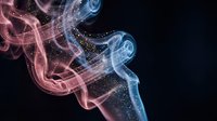 Abstract colorful smoke swirls in pink and blue hues with sparkling particles on dark background for creative design projects and digital art compositions.