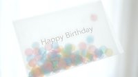 Soft pastel birthday card with colorful bokeh confetti dots and Happy Birthday text, elegant minimalist celebration design for greeting cards.