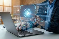 Businessman using laptop with artificial intelligence brain hologram and data analytics dashboard in modern office environment.