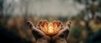 Hands holding glowing lotus flower with warm light, symbolizing spirituality, hope, and inner peace for meditation, wellness, and mindfulness concepts.
