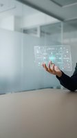 Businesswoman holding holographic tablet with digital network interface in modern office environment for technology and innovation concepts.