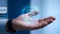 Businessman hand holding glowing digital customer service icon with holographic light effects representing support and communication technology solutions.